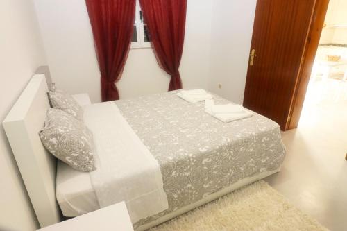 a bedroom with a bed in a room with red curtains at Casa Bela Vista by Gerês Casas in Geres