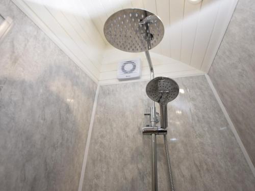 a bathroom with two shower heads on the ceiling at 1 Bed in Teviothead 75346 in Hawick
