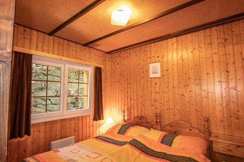 a bedroom with a bed in a wooden wall at Residenz Edelweiss SAAS311 in Saas-Balen