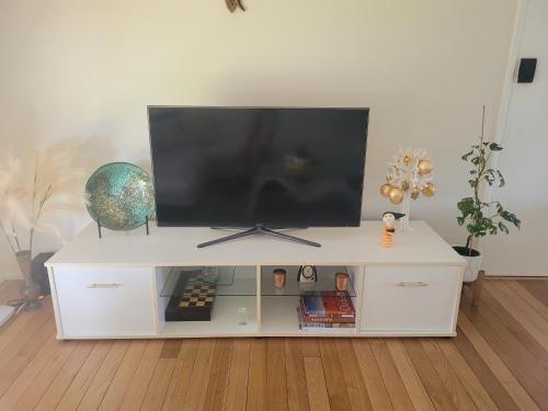 a white entertainment center with a flat screen tv on top at Blue House on Murray River in Cobram
