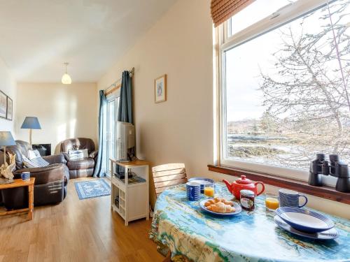 a living room with a table and a large window at 1 bed property in Badachro CA085 in Strath