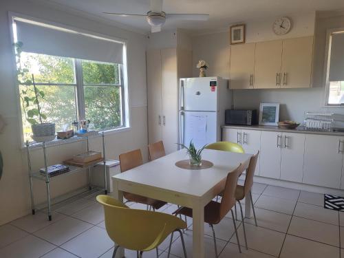 a kitchen with a table and chairs and a refrigerator at Blue House on Murray River in Cobram