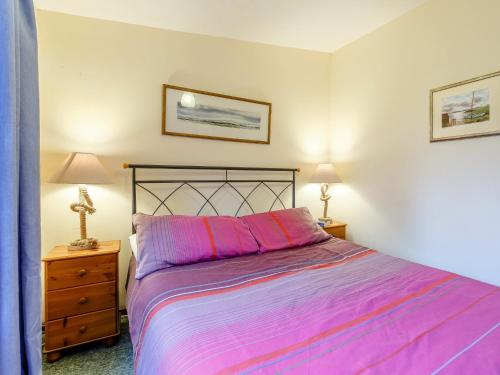a bedroom with a large bed and two lamps at 1 bed property in Badachro CA085 in Strath