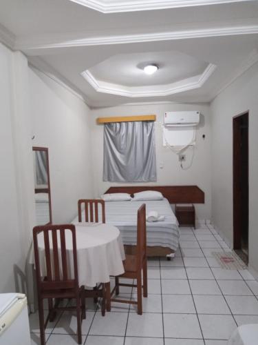 a room with two beds and a table and chairs at NEW'S BUSINESS in Macapá