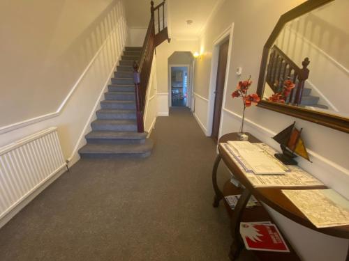 a hallway with a staircase and a stair case at Amazing views across the Moray Firth, Private Suntrap Patio, 300m from the Beach, off street parking! in Nairn