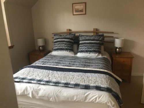 a bed with black and white sheets and pillows at Calgary Farmhouse in Calgary