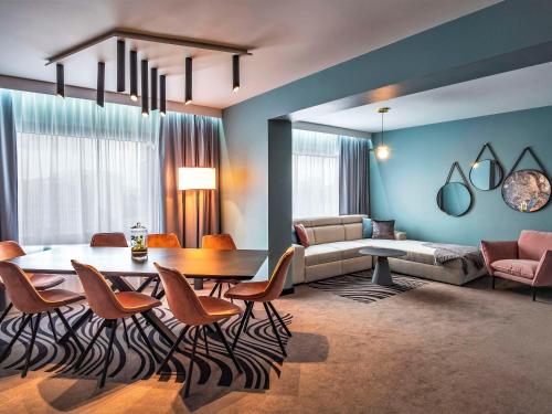 a living room with a table and chairs and a couch at Novotel Katowice Centrum in Katowice