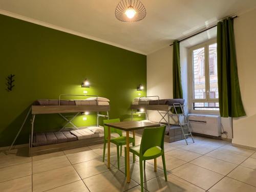 a room with four bunk beds and a table and chairs at Palladini Hostel Rome in Rome