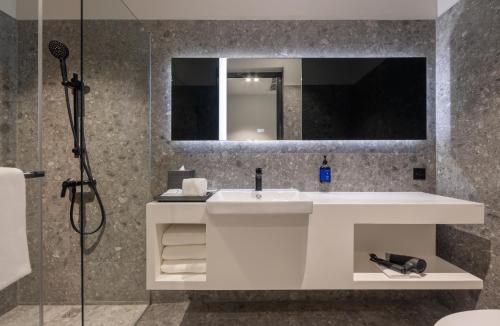 a bathroom with a white sink and a mirror at Travelodge Nimman in Chiang Mai
