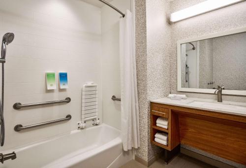 a bathroom with a tub and a sink and a mirror at Home2 Suites by Hilton San Antonio Airport, TX in San Antonio