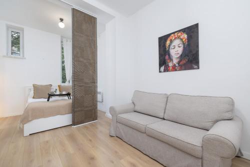 una sala de estar con sofá y una pintura en la pared en Mickiewicza Charming Studio for 2 Guests by Renters, en Cracovia