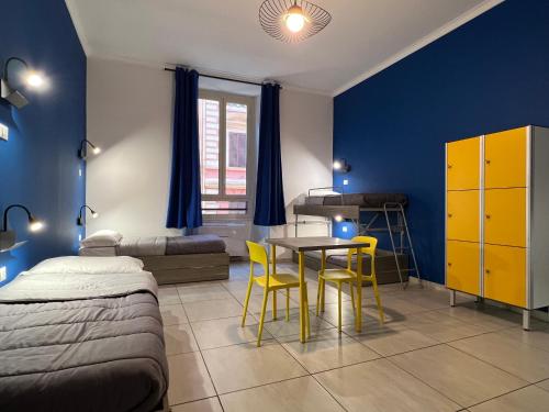 1 dormitorio con 1 cama, mesa y sillas en Palladini Hostel Rome, en Roma