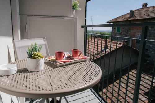 a table with two cups on a balcony at Tra Lago Maggiore e lago d'Orta Appartamento TERRA in Colazza