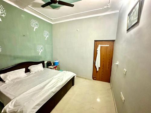a bedroom with a bed and a ceiling fan at Vardan Homes in Mathura