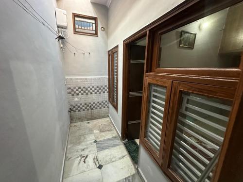 a bathroom with a walk in shower next to a door at Vardan Homes in Mathura