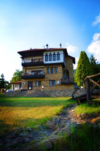 a large stone building in the middle of a field at Archontariki Guesthouse in Poligiros