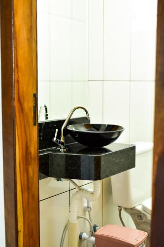 a bathroom with a black sink and a toilet at Casa Flor da Serra in Estivado