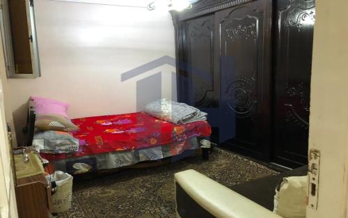 Un pequeño dormitorio con una cama con una manta roja. en BLUE Wave, en Alejandría