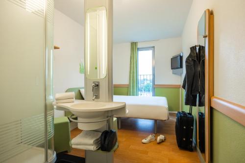 een badkamer met een wastafel en een spiegel bij ibis budget Brugge Centrum Station in Brugge
