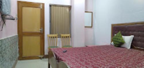 - une chambre avec un lit, 2 portes et des chaises dans l'établissement Hotel City Park Guwahati, à Guwahati