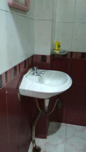 La salle de bains est pourvue d'un lavabo blanc et d'un miroir. dans l'établissement Hotel City Park Guwahati, à Guwahati