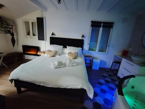a bedroom with a large white bed with a fireplace at Maison SPA DISNEY in Lagny