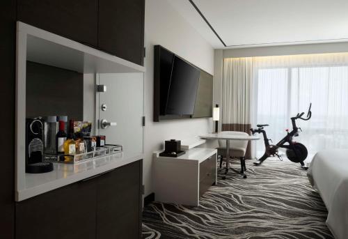 a hotel room with a bed and a desk with a bike at Hilton Miami Aventura in Aventura