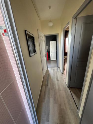 un couloir menant à une chambre avec porte dans l'établissement Appartement Sympas à Puteaux, à Puteaux