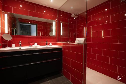 Baño de azulejos rojos con 2 lavabos y espejo en Hôtel du Bois Blanc Domaine d'Epeyssoles Georges Blanc en Vonnas