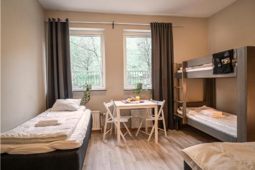 Göteborgs Bed & Breakfast في غوتنبرغ: غرفة بسريرين وطاولة وسرير بطابقين
