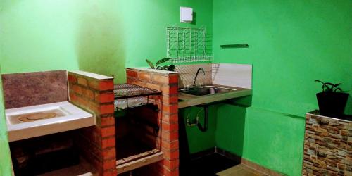 uma cozinha verde com um lavatório e um lavatório em Loft urbano salento em Salento