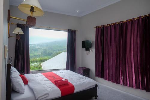 een slaapkamer met een bed en een groot raam bij RedDoorz at Jalan Dieng 3 in Wonosobo