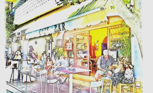 un grupo de personas sentadas fuera de un restaurante en Hostal Yebisah, en Santa Eulària des Riu