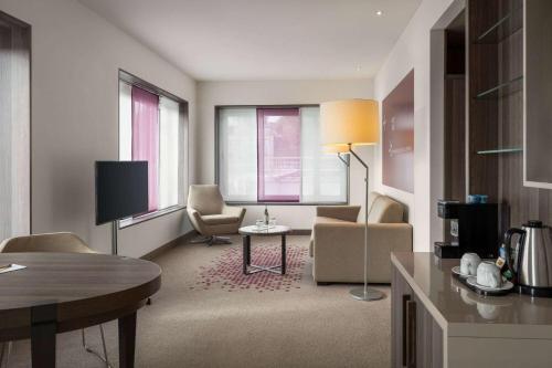a hotel room with a living area with a table and chairs at Vienna House by Wyndham zur Bleiche Schaffhausen in Schaffhausen