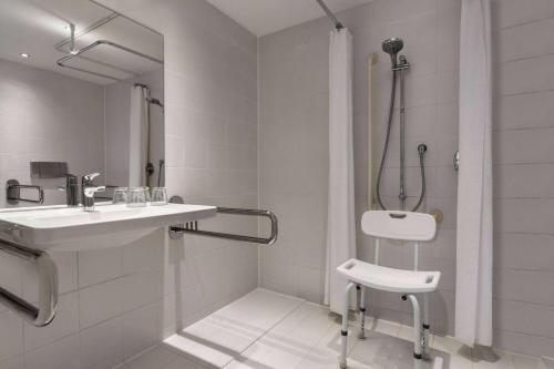 a white bathroom with a shower and a sink at Vienna House Easy by Wyndham Landsberg in Landsberg am Lech