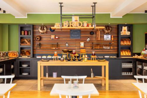 a fast food restaurant with a table and chairs at Vienna House Easy by Wyndham Limburg in Limburg an der Lahn