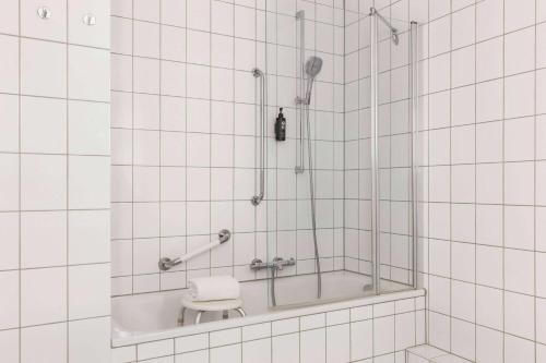 a bathroom with a shower with a toilet in it at Vienna House Easy by Wyndham Limburg in Limburg an der Lahn