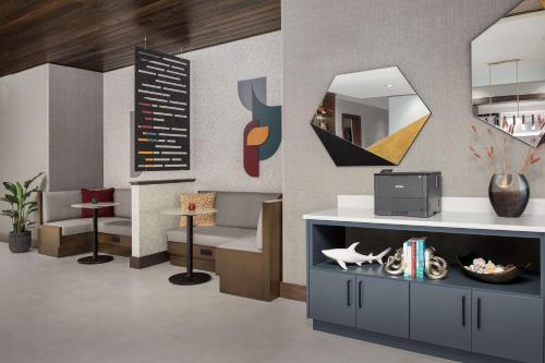 a lobby with a waiting room with a tv at Hampton Inn Orlando Southeast Nona in Orlando