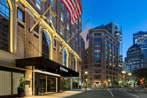 een straat met een gebouw met een Amerikaanse vlag erop bij Hilton Boston Park Plaza in Boston