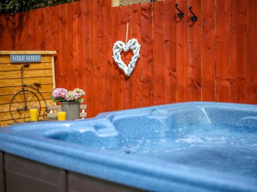 una bañera azul con un corazón colgando de una valla de madera en 1 Bed in Nr. Rothbury 82147 en Longhorsley