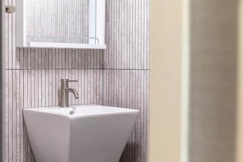 a bathroom with a white sink and a mirror at Suncheonbay Reed Field Pension in Suncheon