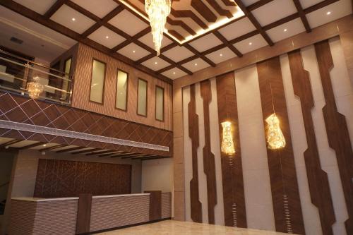 a lobby with a chandelier on the wall at HOTEL VKJ INN Aluva in Alwaye