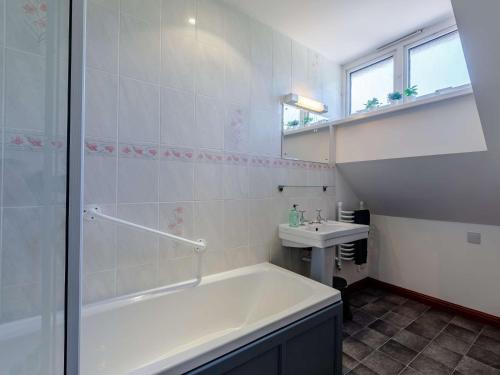 Baño blanco con bañera y lavamanos en 4 Bed in Netley 82920, en Netley