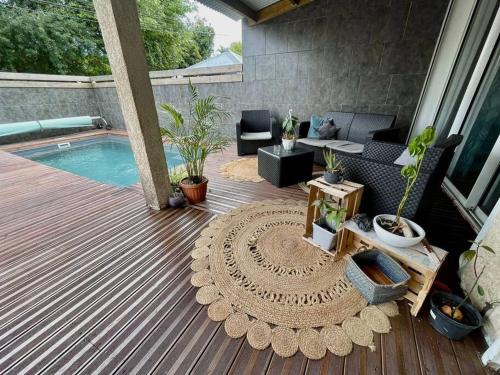 un patio con una piscina con una mesa y un sofá y una sidra de mesa en La villa Loca Reunion, en Saint-Joseph