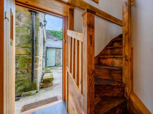 a wooden door leading into a room with a staircase at 2 Bed in Rothbury 83597 in Rothbury
