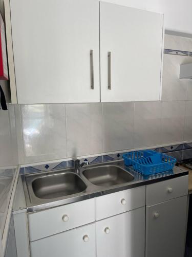 a kitchen with a stainless steel sink and white cabinets at West Coast Peniche in Peniche