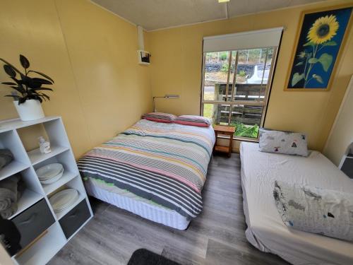 um pequeno quarto com uma cama e uma janela em Tullah TrackSide - Galena Cabin em Tullah