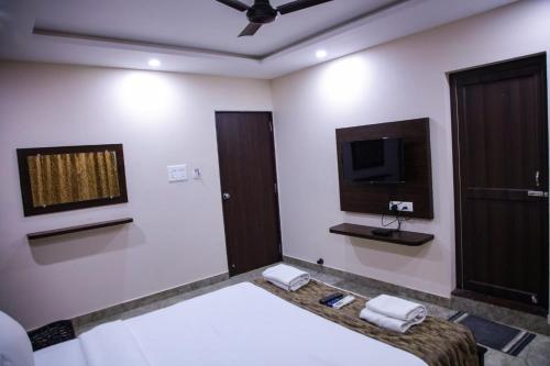 ポンディシェリにあるHotel Grand Sapphire & Elite Suiteのテレビとベッドがあるホテルの部屋