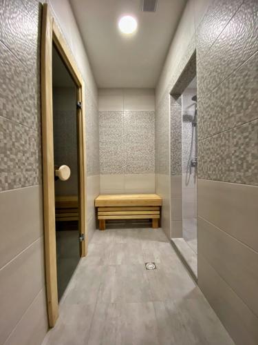 a walk in shower with a bench in a bathroom at Vershyna in Dragobrat