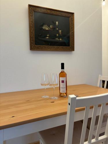a bottle of wine and two wine glasses on a table at Wick Home Apartment 3 Lahr-Burgheim in Burgheim